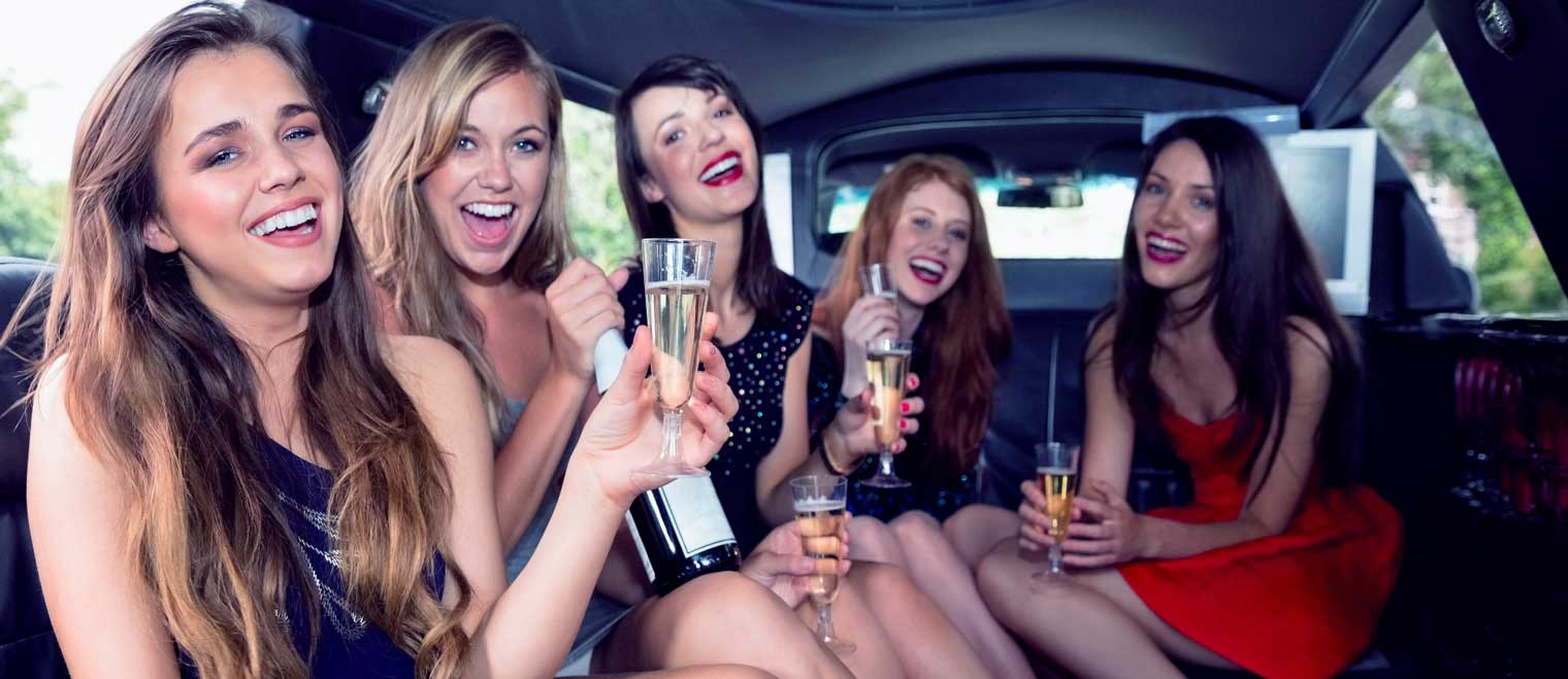 Hen’s party group celebrating with a limousine