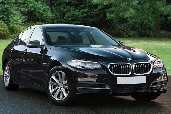 Private chauffeur opening the door of a luxury vehicle